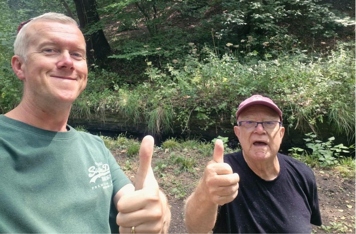 Ascend companion and an older gentleman giving a thumbs up on a woodland walk